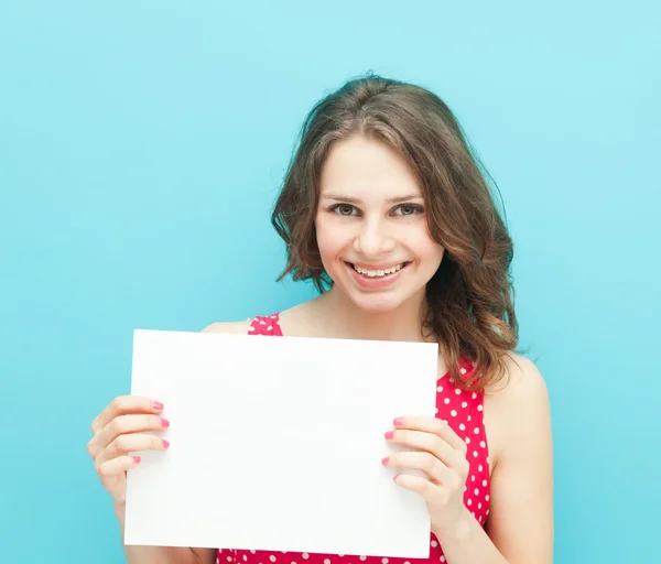 Belle fille avec une feuille blanche de papier sur un fond bleu — Photo