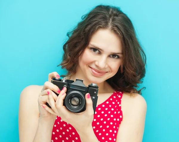 Piękna dziewczyna z vintage zdjęcie aparatu na niebieskim tle w — Zdjęcie stockowe