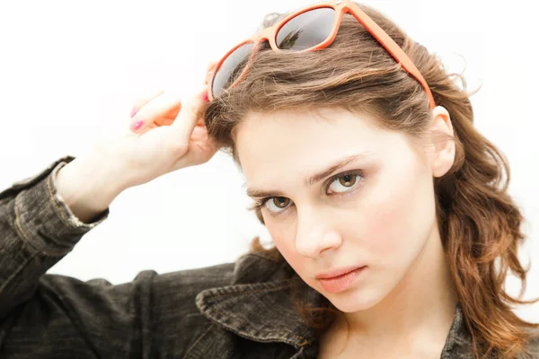 Kaunis nuori nainen laittaa aurinkolasit, eristetty valkoinen — kuvapankkivalokuva