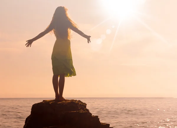 Chica se encuentra con el amanecer en la orilla del mar, en enfoque suave —  Fotos de Stock