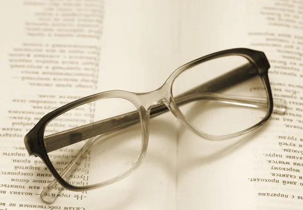 Gafas de lectura acostado en un libro abierto, imagen de estilo retro —  Fotos de Stock