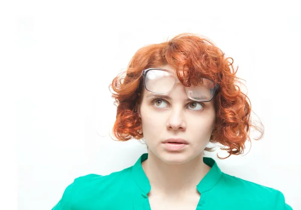 Rudowłosa dziewczyna w okularach myślenia na białym tle — Zdjęcie stockowe