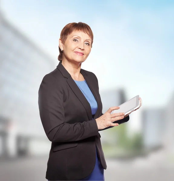 Attractive woman 50 years old with a tablet in hands — Stock Photo, Image