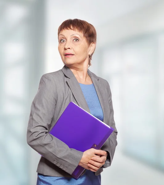 Attractive woman 50 years old with a folder for documents — Stock Photo, Image