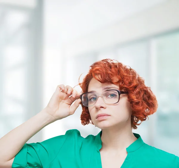 Sreious red-haired girl in glasses thinking — Stock Photo, Image