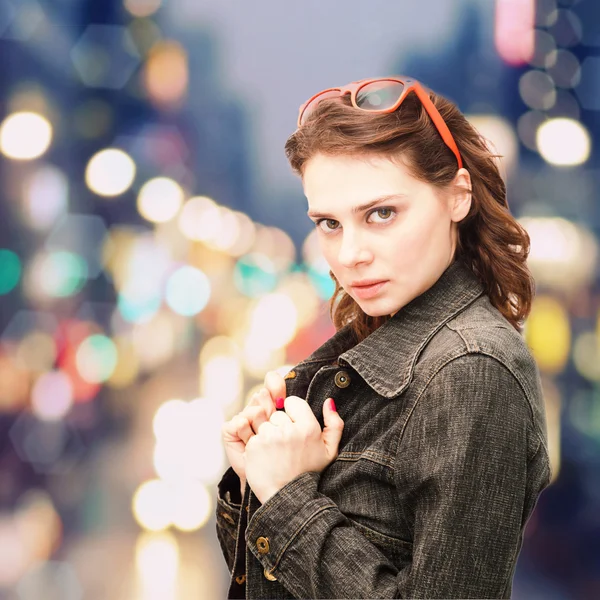 Beautiful young woman puts on sunglasses — Stock Photo, Image