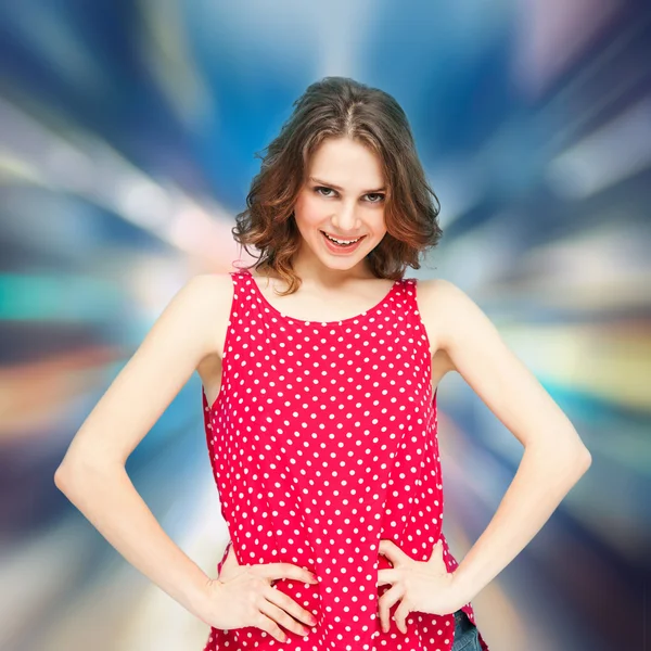 Beautiful girl in a red blouse with polka dots on a blurred  bac — Stock Photo, Image