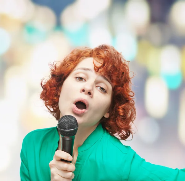 Bonito jovem mulher cantando em um microfone — Fotografia de Stock