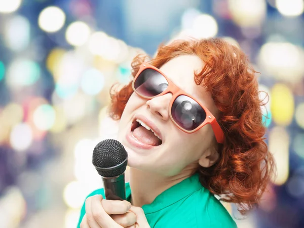 Niedliche junge Frau singt in ein Mikrofon — Stockfoto