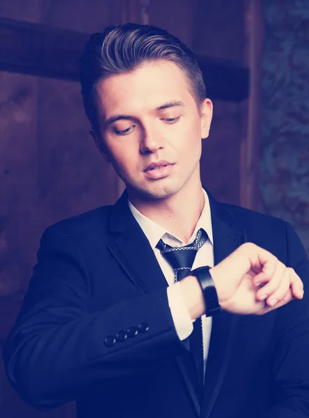 Aantrekkelijke jonge zakenman kijken naar zijn horloge — Stockfoto