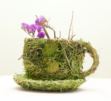 çim ve yaprakları ile süslenmiş kupa