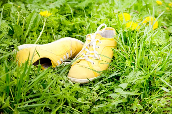 Yellow sneakers on green grass — Stock Photo, Image