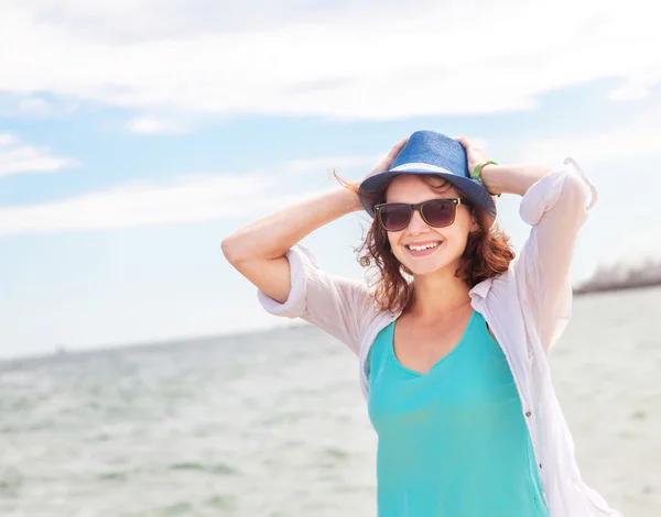 Mooi meisje in een hoed op een achtergrond van de zee, in zachte focu — Stockfoto