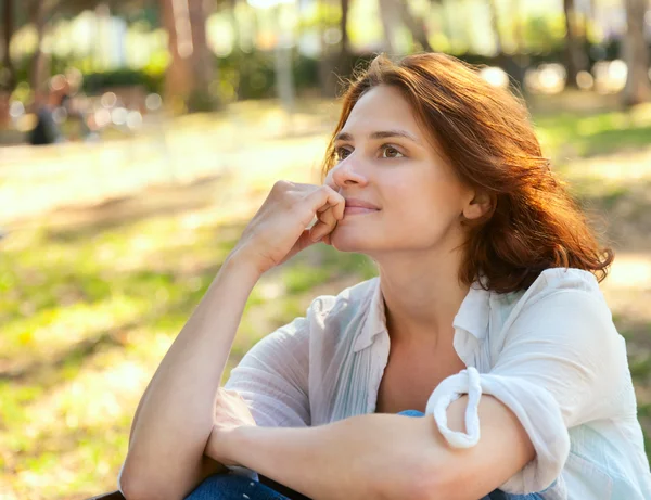 Beautiful girl sitting in the park — Stock Photo, Image