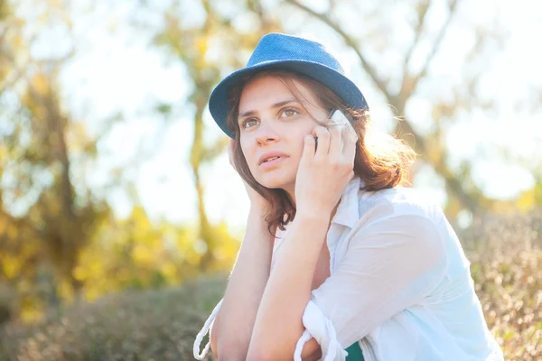 Menina bonita fala no telefone celular no parque — Fotografia de Stock