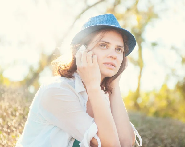 Piękna dziewczyna mówi na telefon komórkowy w parku — Zdjęcie stockowe