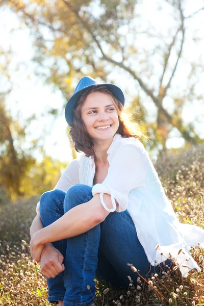 Bella ragazza seduta nel bagliore del sole al tramonto — Foto Stock