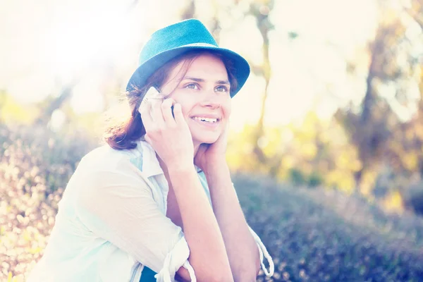 Menina bonita fala no telefone celular no parque — Fotografia de Stock