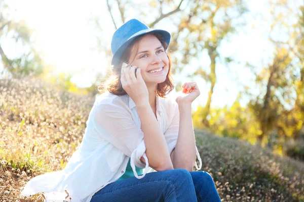 Piękna dziewczyna mówi na telefon komórkowy w parku — Zdjęcie stockowe