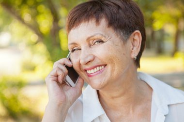 güzel bir kadın ile bir cep telefonu açık havada 50 yılı