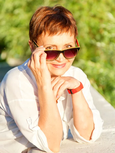 Beautiful woman 50 years in sunglasses, Outdoors — Stock Photo, Image