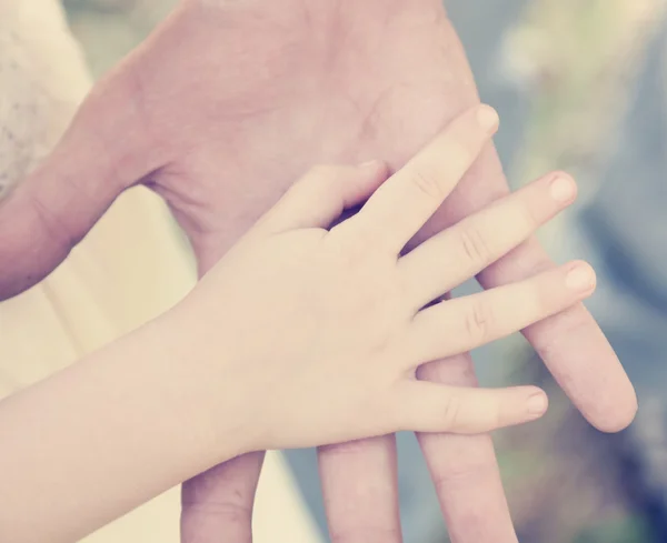 Kinderhand auf der Hand des Erwachsenen — Stockfoto