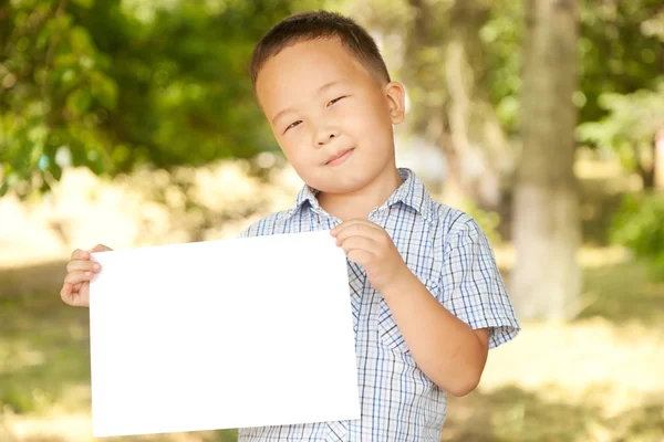 Asiatischer Junge 6 Jahre alt mit einem Blatt Papier im Park — Stockfoto