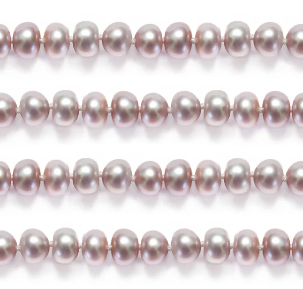 Ciągi delikatne różowe perły na białym tle — Zdjęcie stockowe