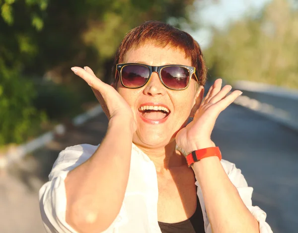 Привлекательная женщина 50 лет в солнечных очках — стоковое фото
