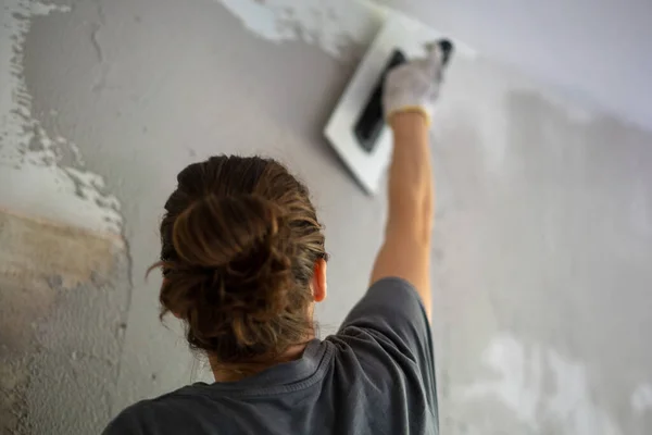 Jovem Mulher Fazendo Reparos Casa Aplicando Gesso Usando Uma Espátula — Fotografia de Stock