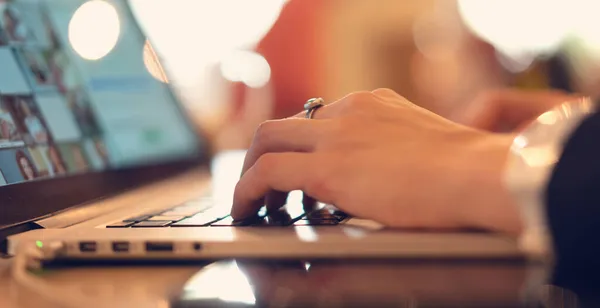 Γυναικεία χέρια στο πληκτρολόγιο laptop, σε απαλή εστίαση. Ελεύθερος επαγγελματίας που εργάζεται σε ένα καφέ — Φωτογραφία Αρχείου