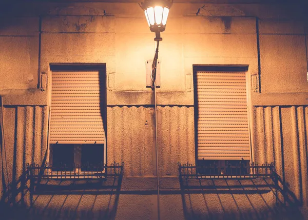 Lanterne sur le mur d'un bâtiment avec balcons la nuit. Architecture rétro européenne fond et texture — Photo