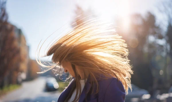 空飛ぶ髪を持つ晴れた日の光の街の若い幸せな女性の肖像画 — ストック写真