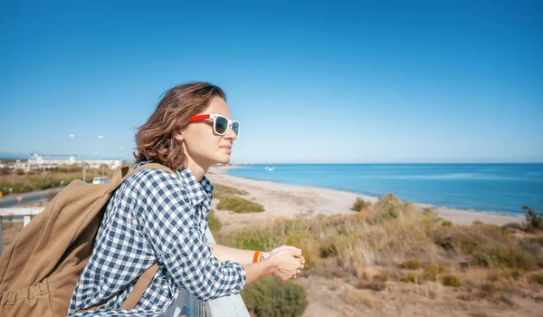 Young Woman Traveler Backpack Sunglasses Admires Landscape Blue Sea — стоковое фото