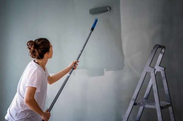 Young Woman Paints Walls Her House Olive Green Using Roller — Stock Photo, Image