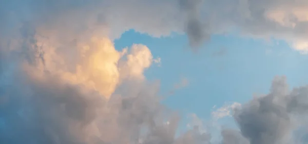 Блакитне небо з білими і жовтими пухнастими хмарами, абстрактним фоном і форматом текстури банера — стокове фото