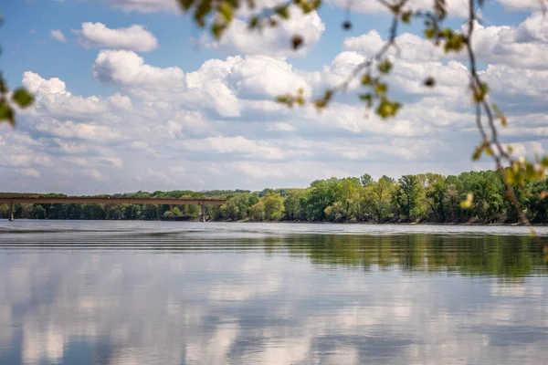 Beautiful summer landscape. River and green hills, clouds reflected in water