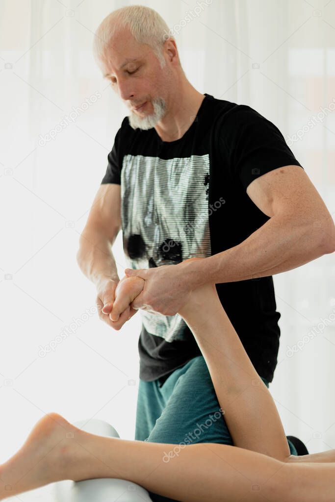 Male massage therapist doing foot massage