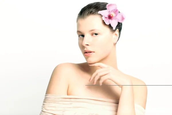 Beautiful female face with healthy skin and flower in hair in spa — Stock Photo, Image