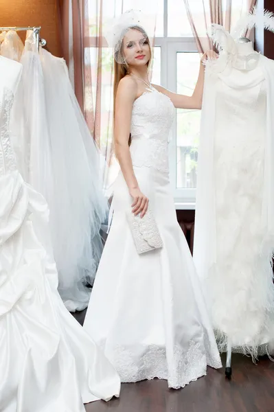 The bride trying on dresses in the bridal salon — Stock Photo, Image