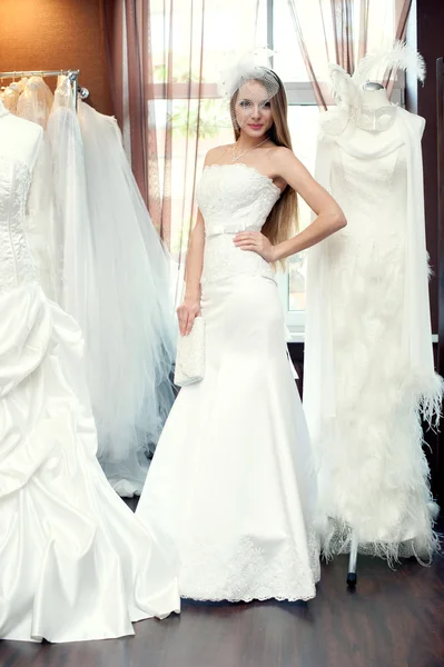 The bride trying on dresses in the bridal salon — Stock Photo, Image