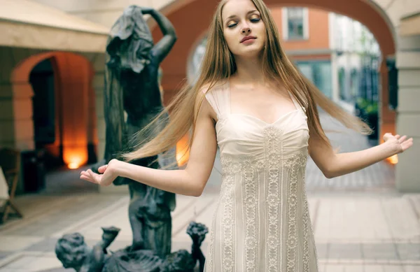 Красивая молодая женщина позирует на улице, показывая платья — стоковое фото