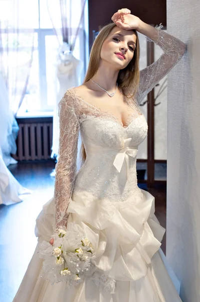 La mariée essayant des robes dans le salon de mariée Photos De Stock Libres De Droits