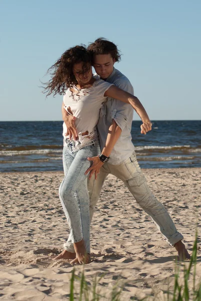 Pareja joven bailando tango en la playa — Foto de Stock