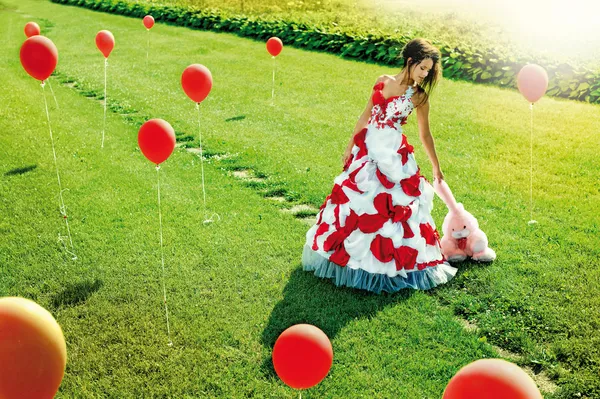 Красивая молодая девушка, стоящая посреди полевых шаров — стоковое фото