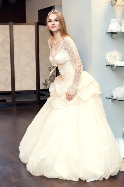 A noiva experimentando vestidos no salão de noivas — Fotografia de Stock