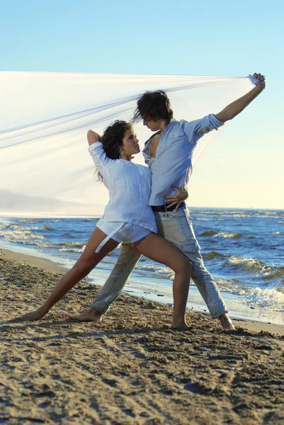 Jong koppel dansen tango op het strand — Stockfoto