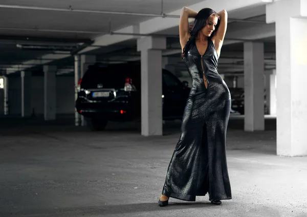 Girl in an underground garage with a car — Stock Photo, Image