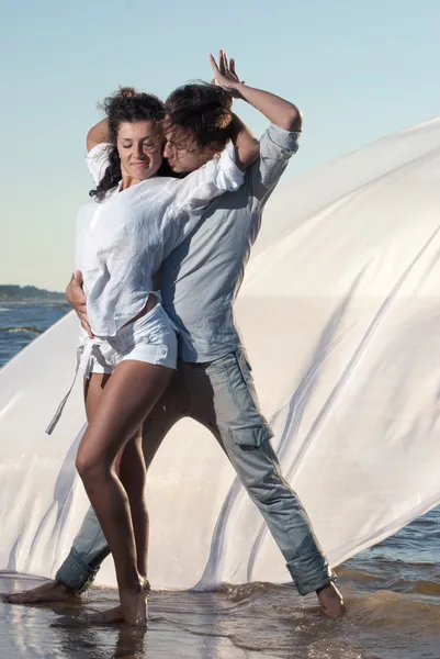 Pareja joven bailando sobre un fondo de mar — Foto de Stock