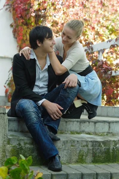 Cute young couple talking in the garden on stairs — Stok fotoğraf